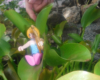 a mermaid figure sitting on a green plant
