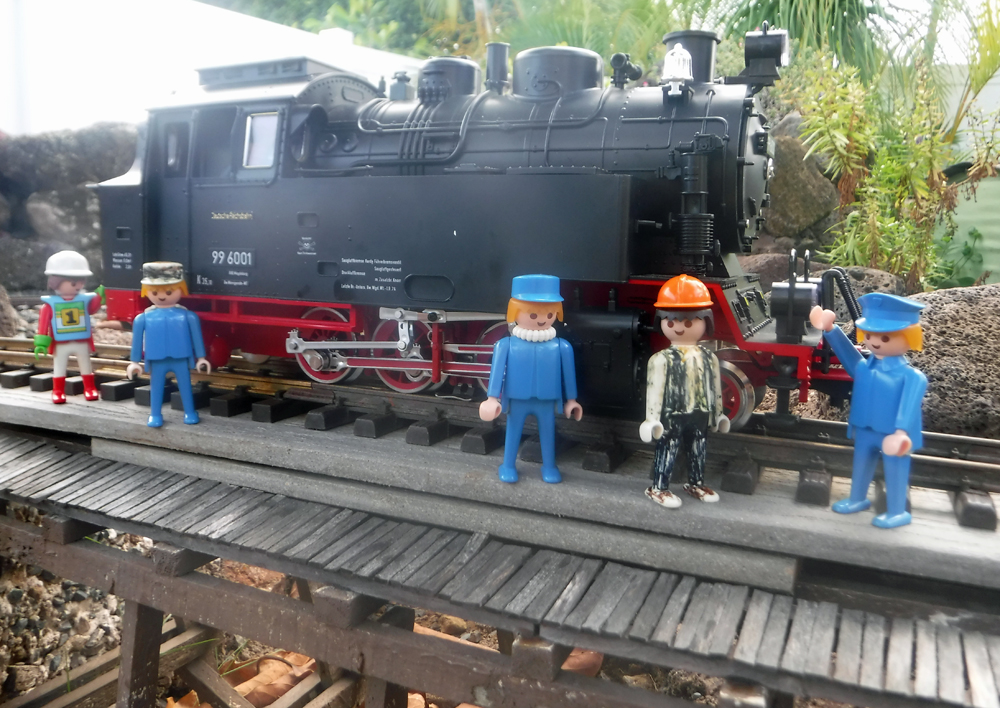 several model figures in front of a black steam engine