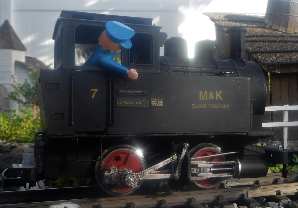 blue figure in cab of black model engine