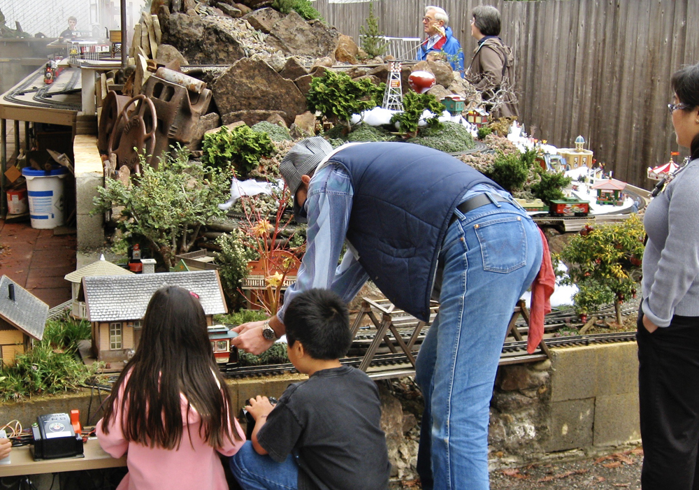 children and adults watching a garden railway