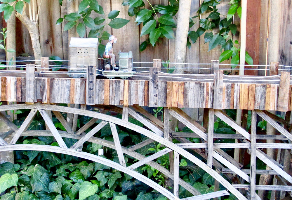 train crossing wooden bridge on garden railway