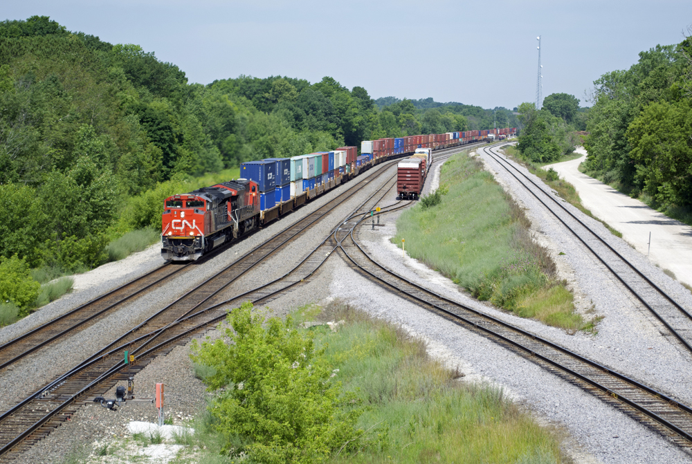 Color photo of interchange yard with diesel locomotives and freight cars.