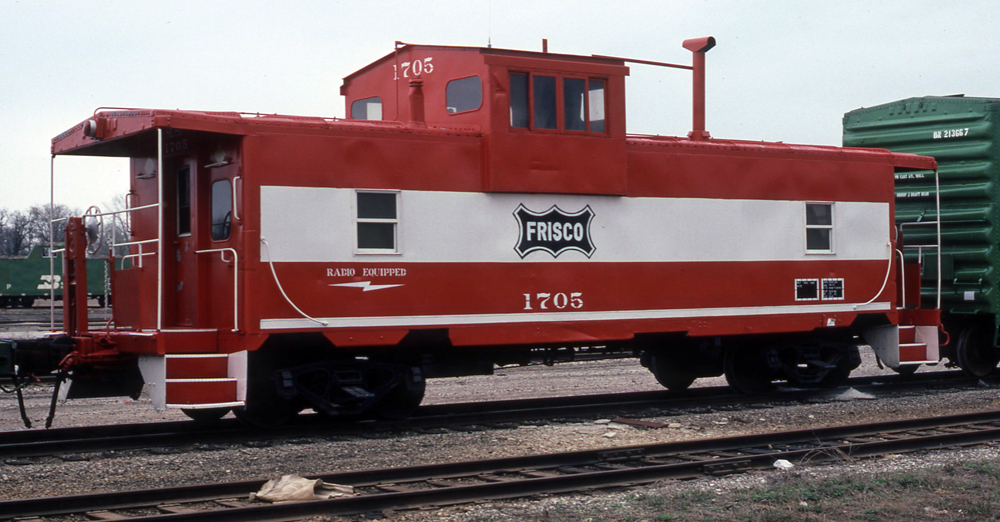 Color photo of steel cupola caboose in Mandarin Orange and white paint.
