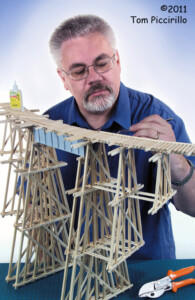 man in front of model wood trestle