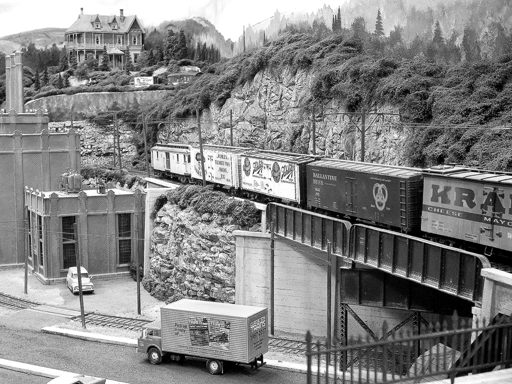 black and white photo of train passing through a town