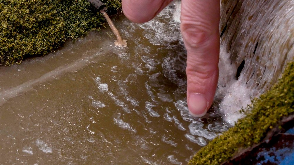 An image of a finger cleaning model railroad scenery