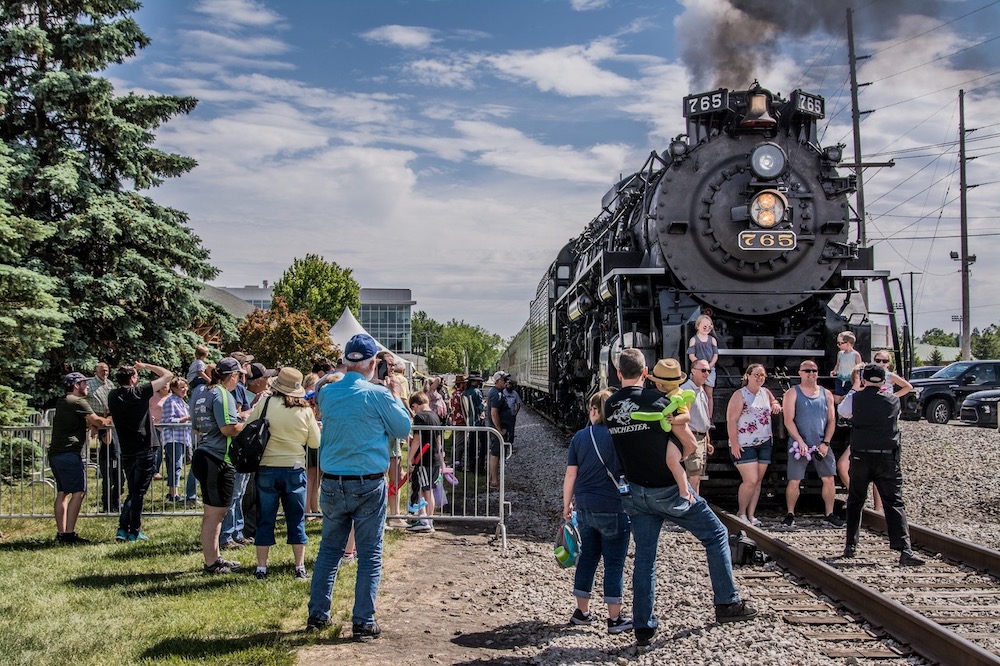 People gather around a steam locomotive during an event
