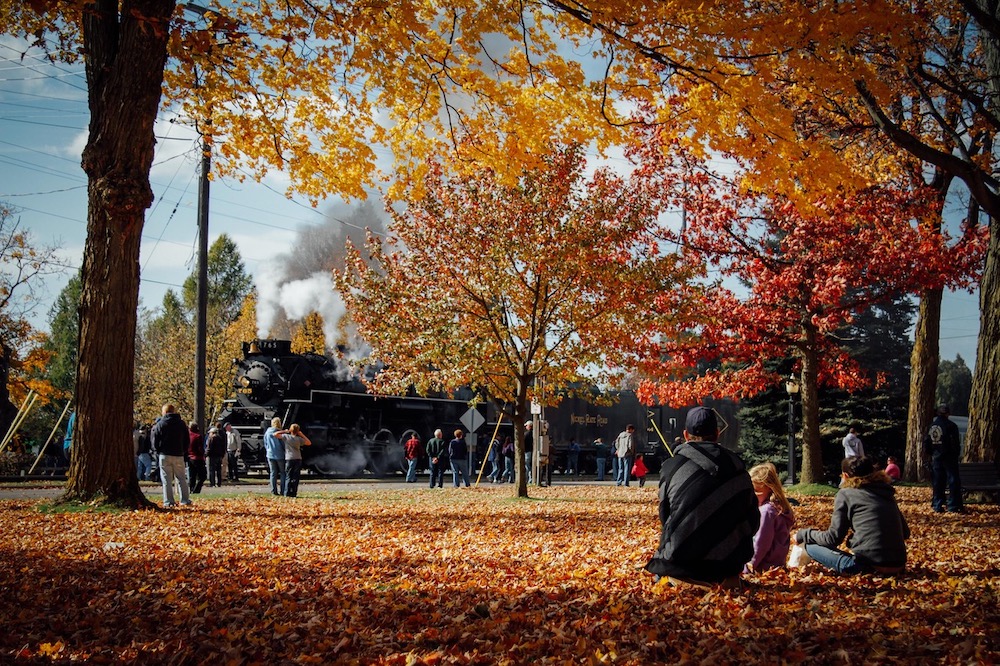 Steam locomotive waiting to depart during a fall day.