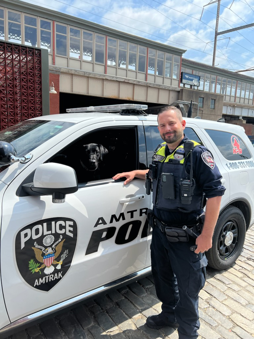 officer by car with dog in it