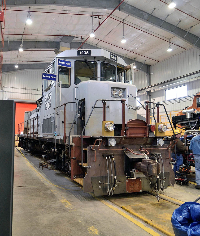 Locomotive in gray primer paint inside shop building