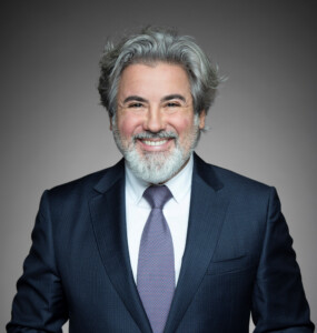 Smiling man with gray hair and full beard