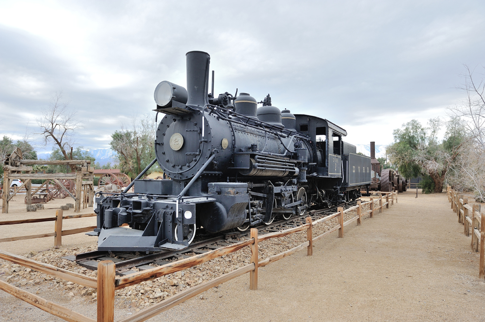 Steam locomotive on display in desert setting