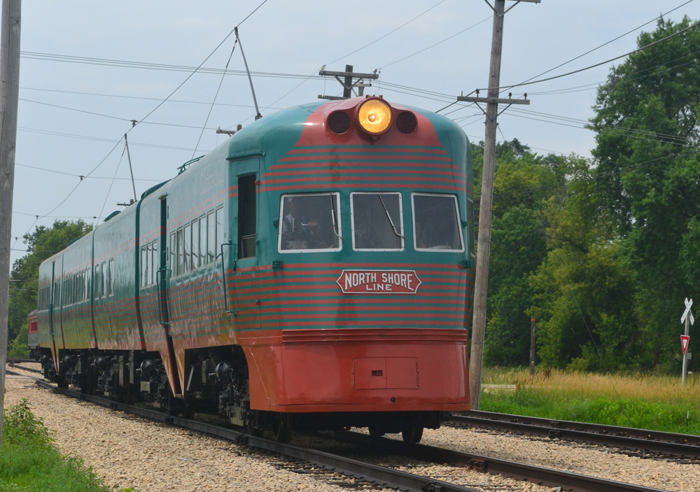 Green and orange streamlined electric interurban train