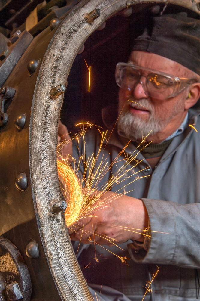 Man working in locomotive with sparks flying