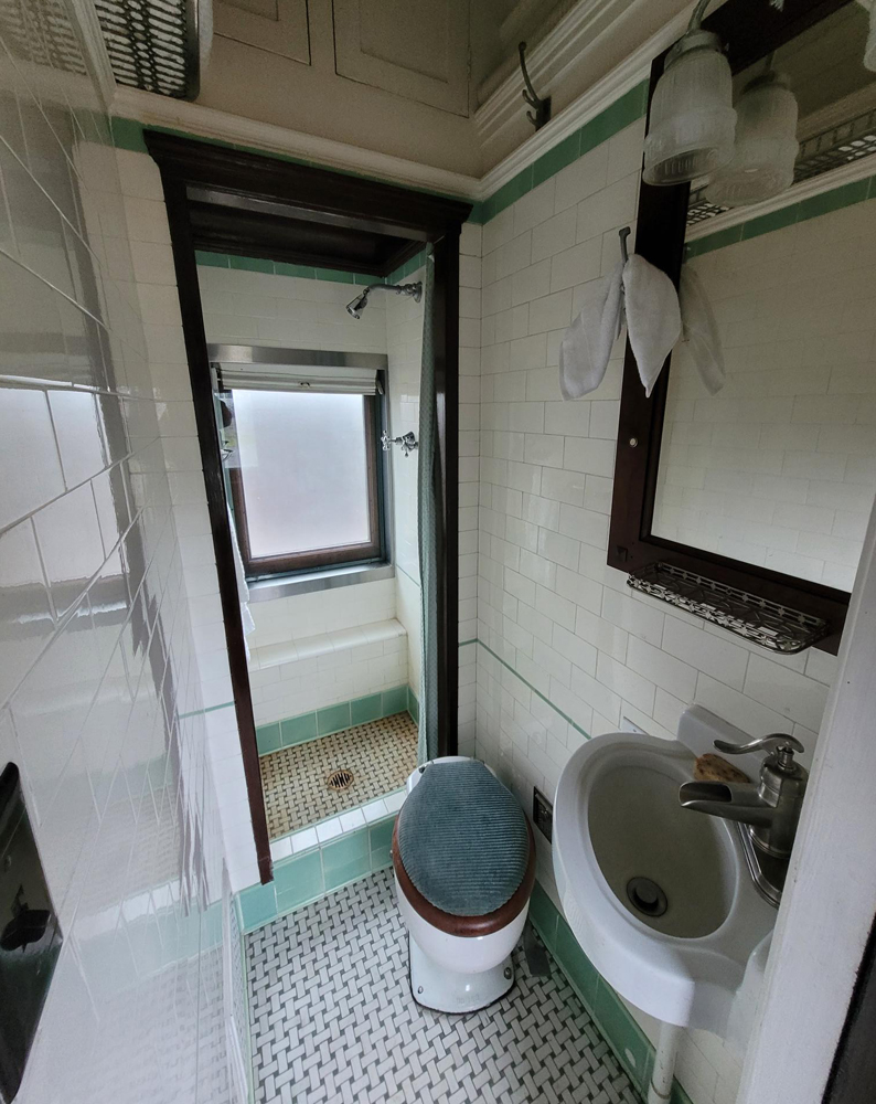 View of private car bathroom with shower and tile finish