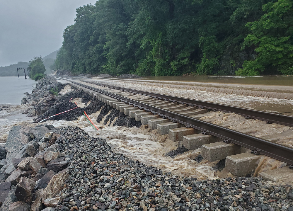 Railroad track with unsupported ties and second track obscured by water