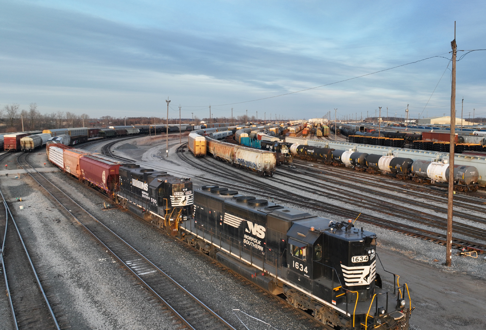 Two black diesels with high short hoods work at yard
