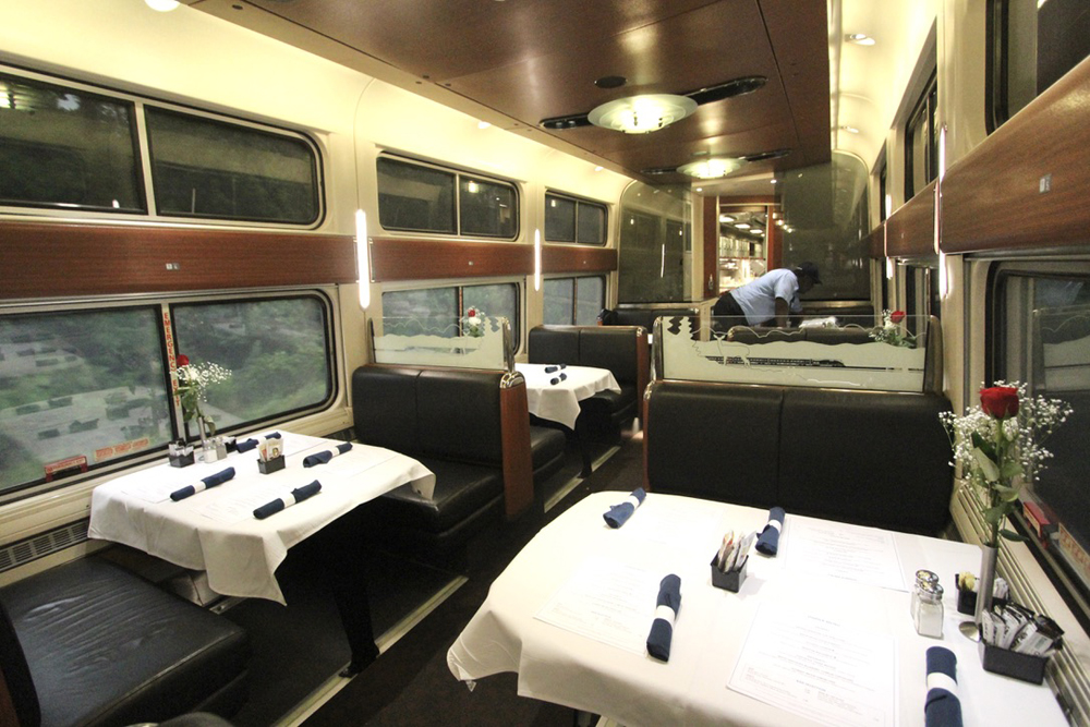 Interior of dining car with linen tableclothes and cloth napkins on tables