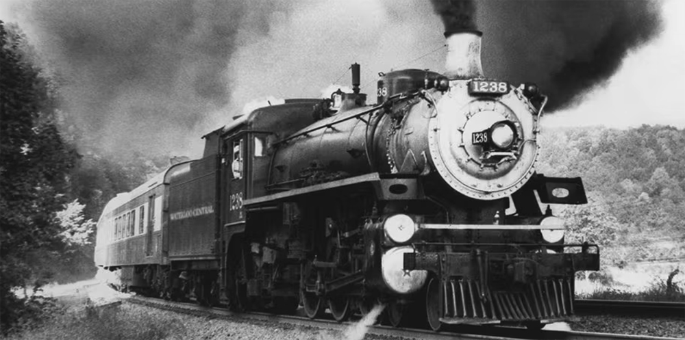 Black and white photo of steam locomotive with passenger train