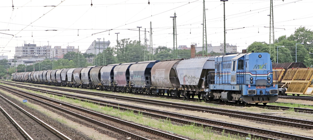 Train with one blue diesel locomotive and a short string of grain hoppers