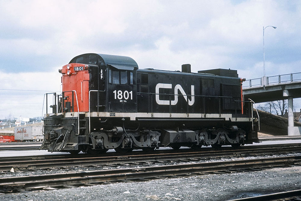 RSC24 diesel locomotive in yard with highway overpass