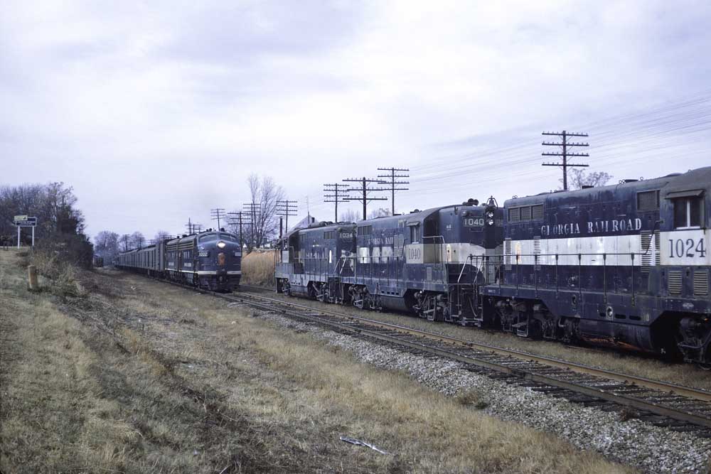 Blue-and-white Georgia Railroad diesel locomotives on passing freight trains