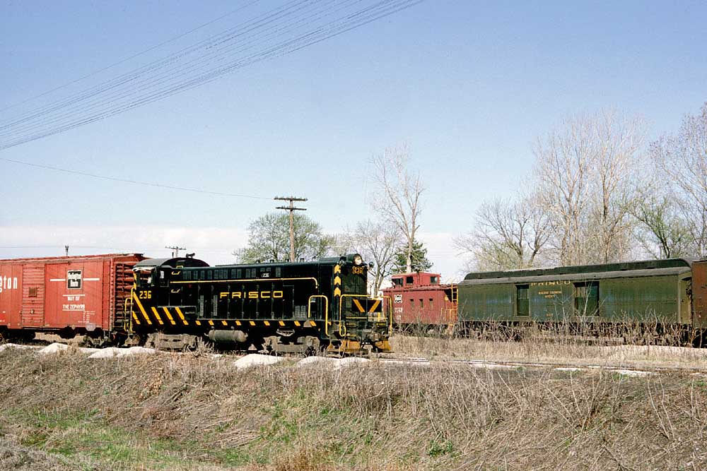 Black-and-yellow diesel locomotive handling freight cars during Frisco caboose ride