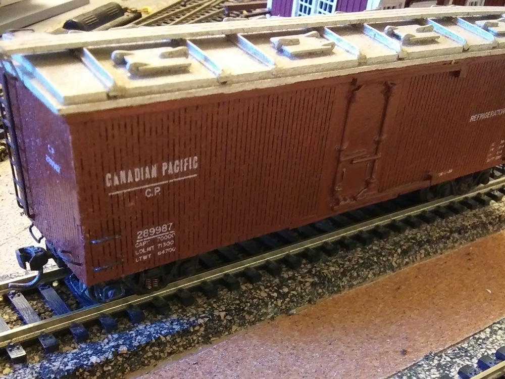 A model of a brown wood-sided reefer car with ice hatches along the length of the roof