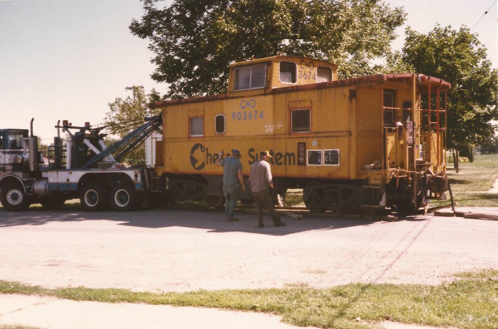 Caboose being towed by truck.