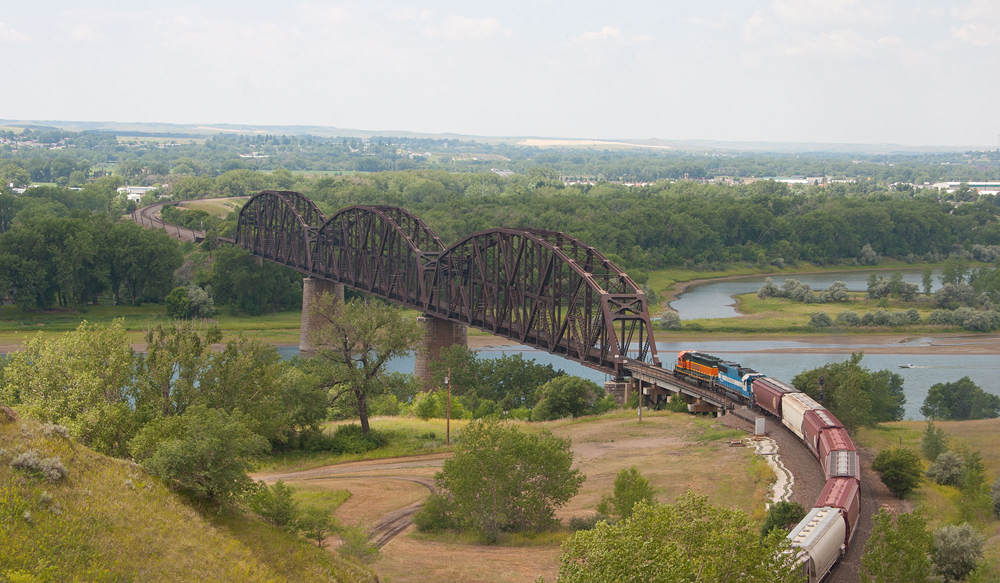 Train approaching large three-span bridge in the middle of S curve