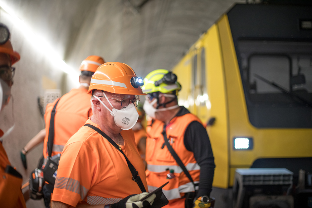 Three men in safety gear inside tunnel