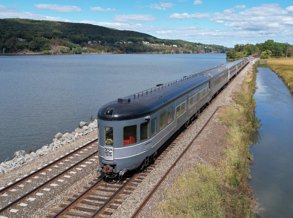 Round-end observation car on train running next to river