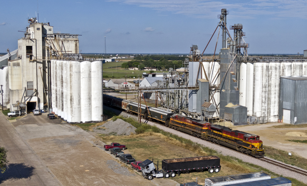 Aerial view of Kansas City Southern train passing grain elevators in Texas