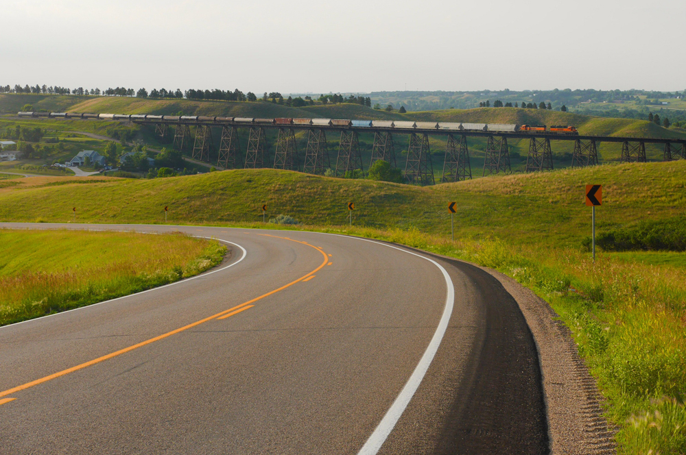 Rail bridge in distance with highway in foreground