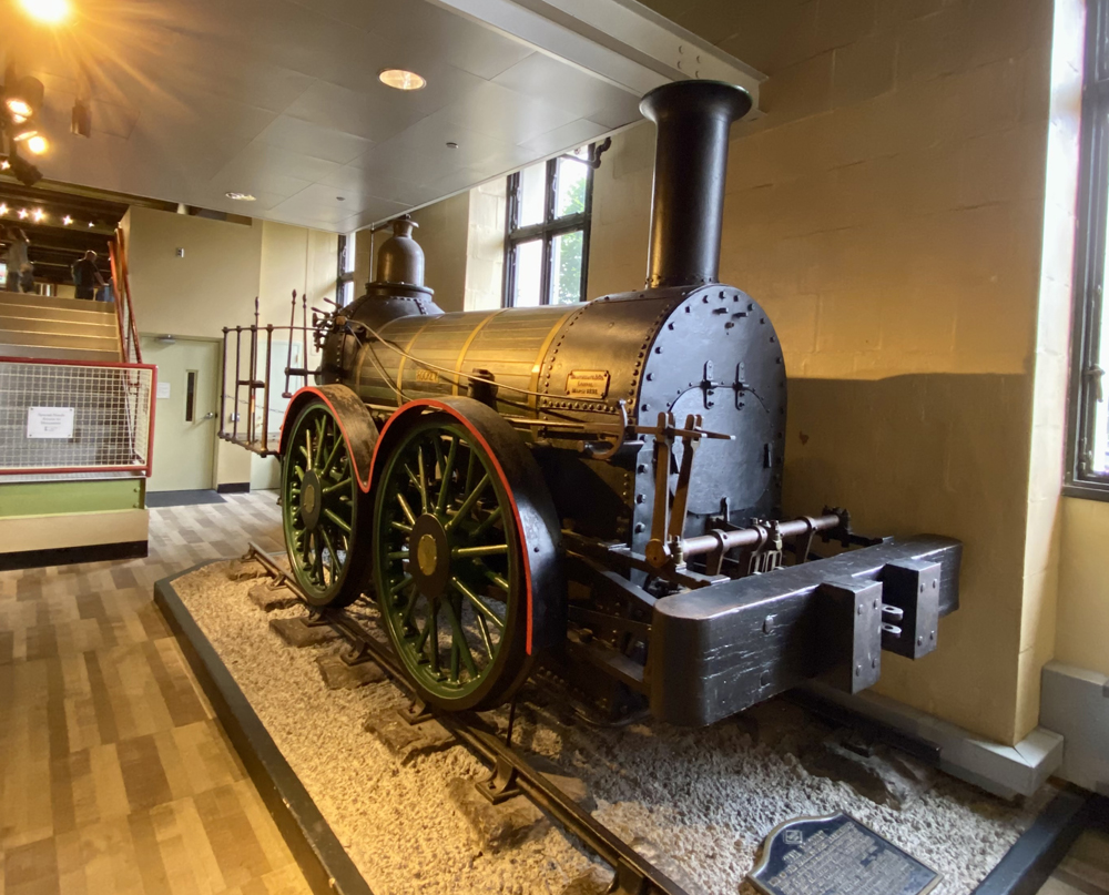 Early four-wheeled steam locomotive in museum building