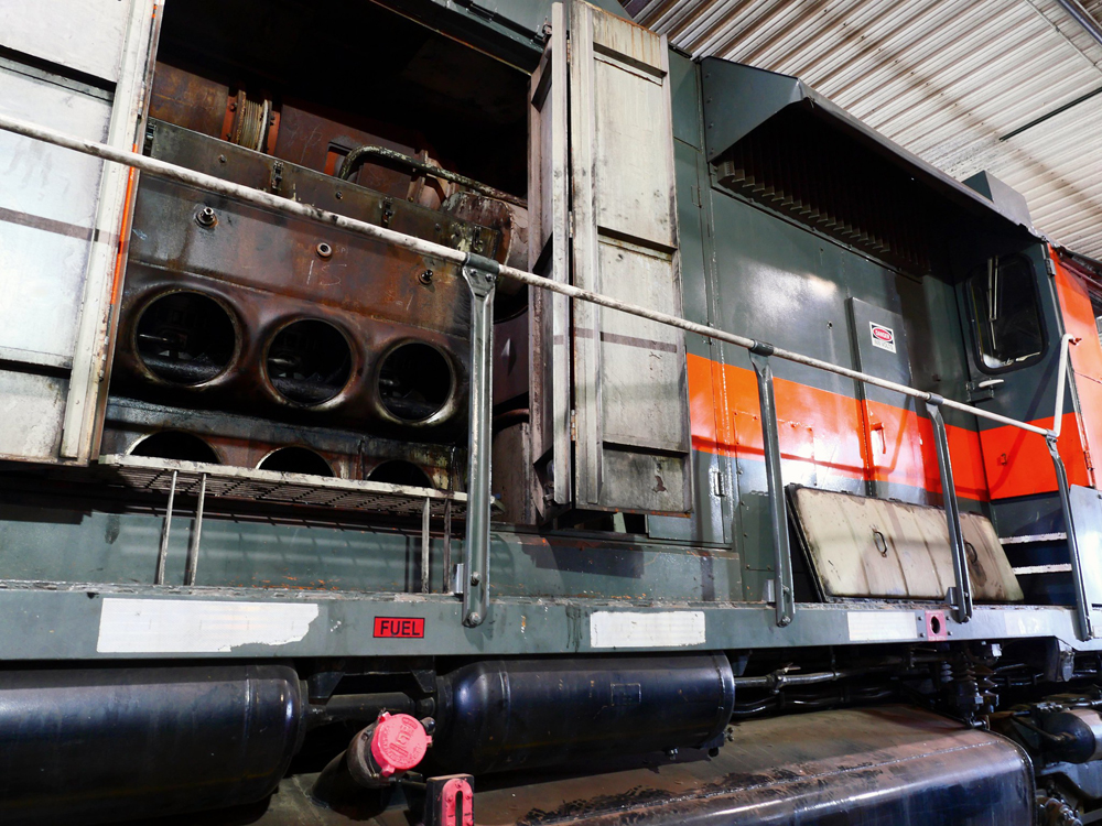 Locomotive engine is visible thorough open doors on long hood