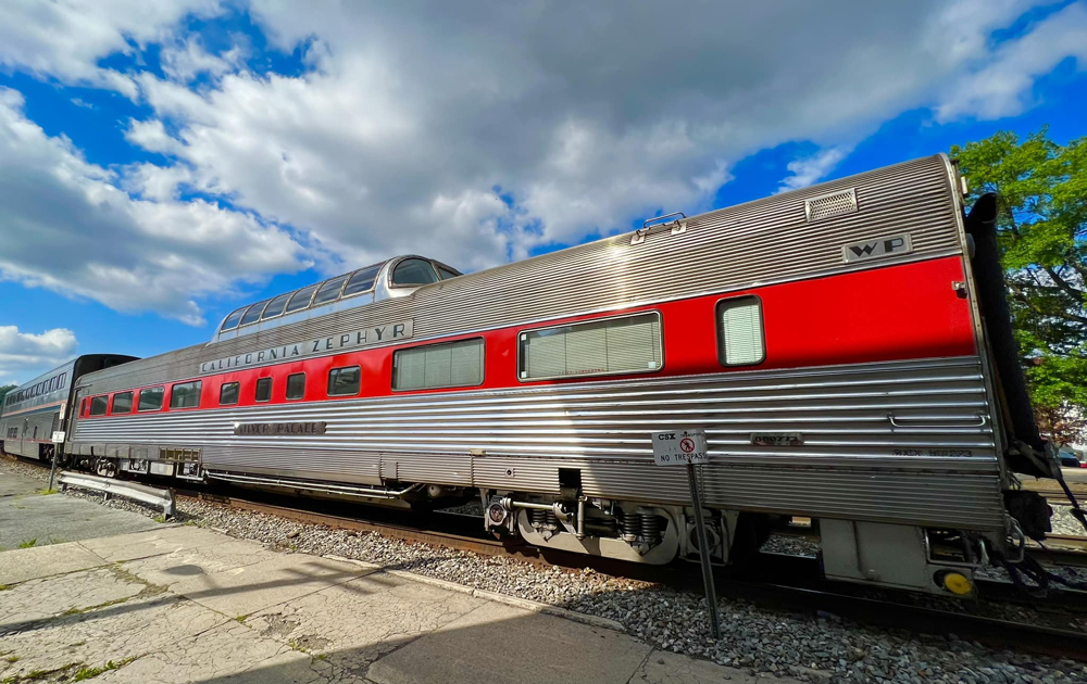 Stainless steel dome car with red stripe along windows
