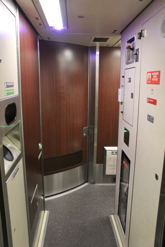 Aisle leading to corner doorway in sleeping car