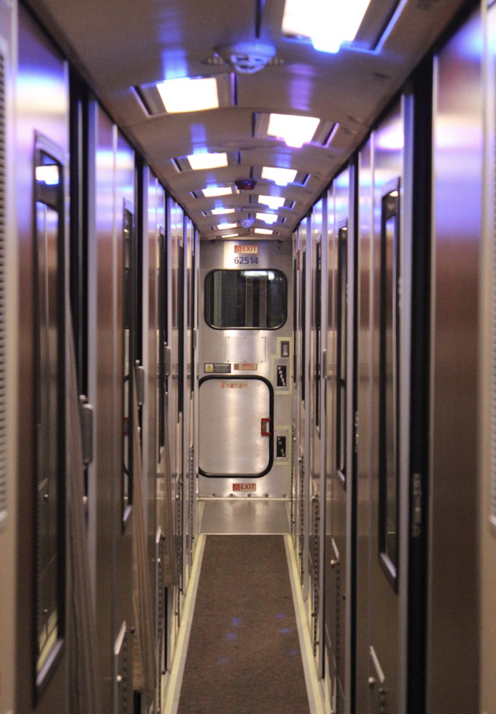 View of aisle in sleeping car with doors to roomettes on either side