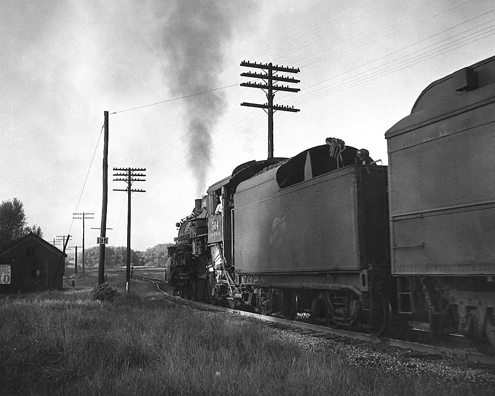 Steam locomotive pointed away from the camera on trackage that would become the Elroy-Sparta State Trail