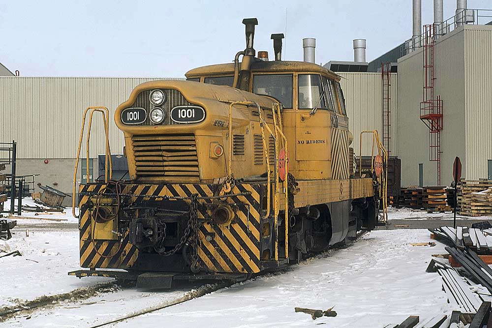 Yellow-and-black centercab GMDH1 diesel-hydraulic locomotives outside factory