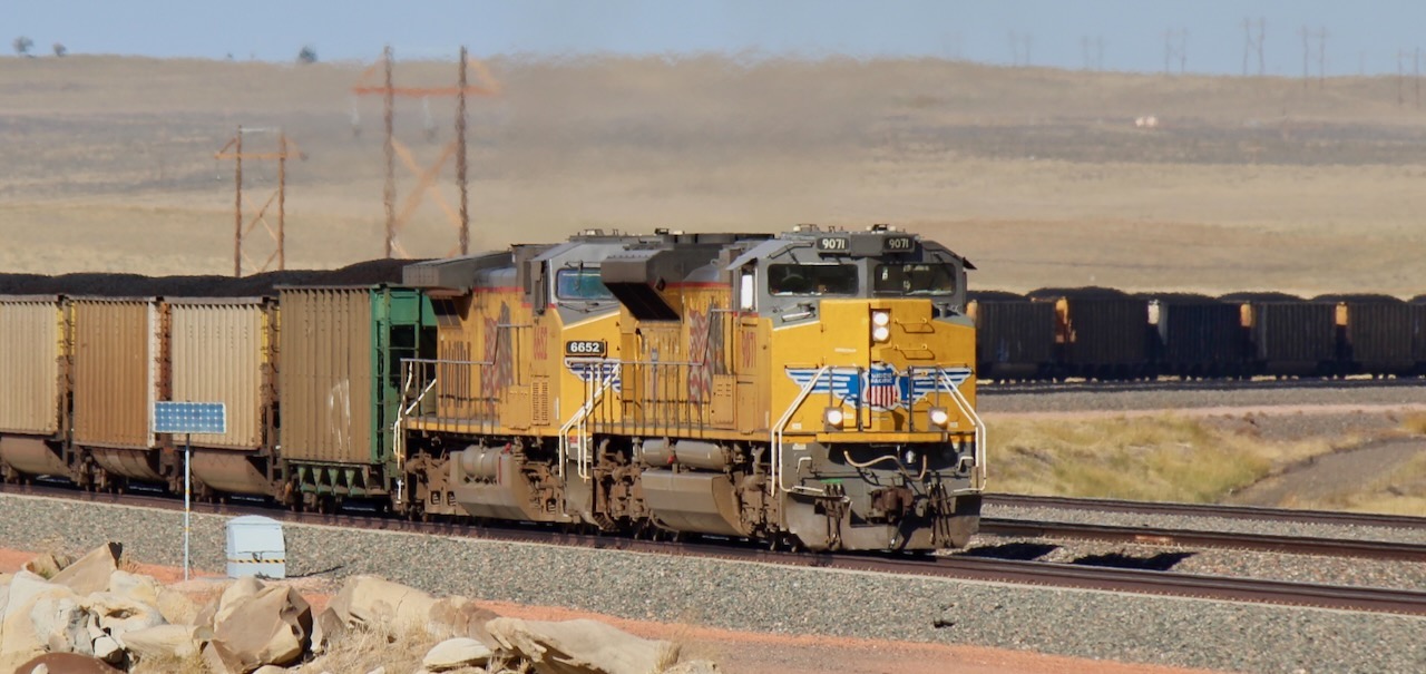 Two yellow diesel locomotives pulling a coal train. Progress Rail files antitrust suit against Wabtec