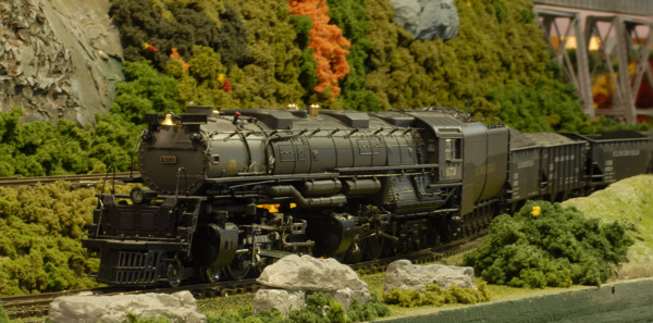 close up of model steam locomotive on layout with lots of greenery
