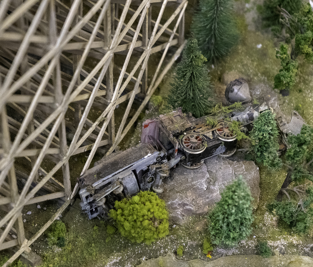 A crashed locomotive on a model railroad layout