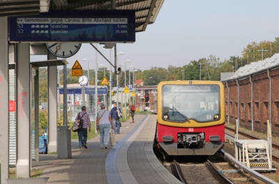 Yellow and red DMU passenger train at station.