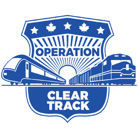 Blue police-badge logo with two passenger trains. Amtrak Police Department and Operation Lifesaver mobilize 'Operation Clear Track'