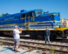 photographer taking picture of guy in front of engine