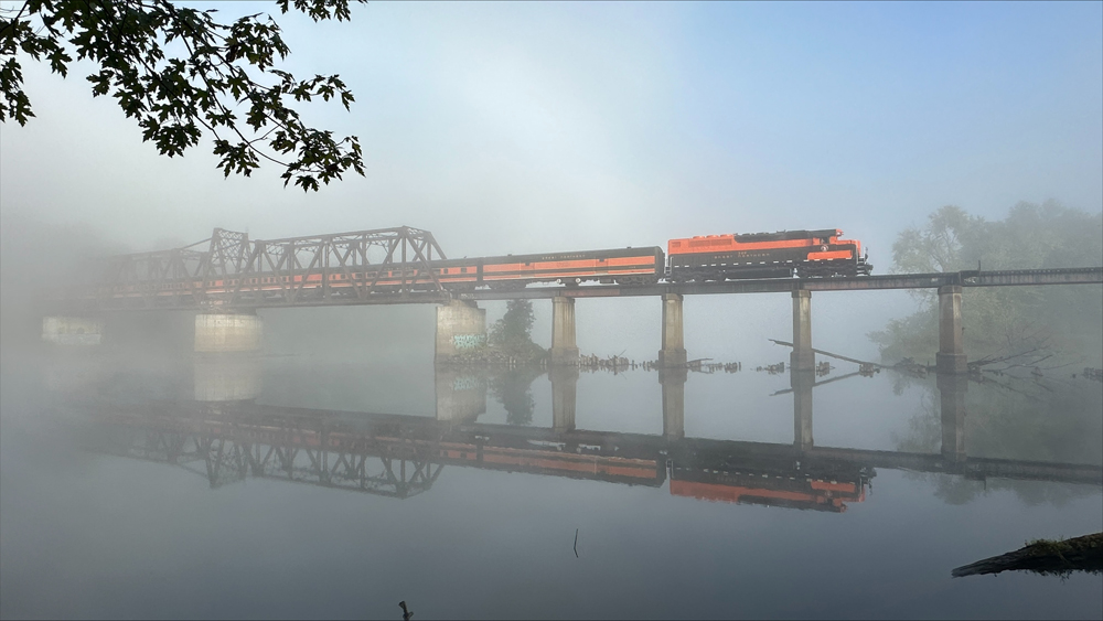 fog-filled landscape with orange diesel on bridge.