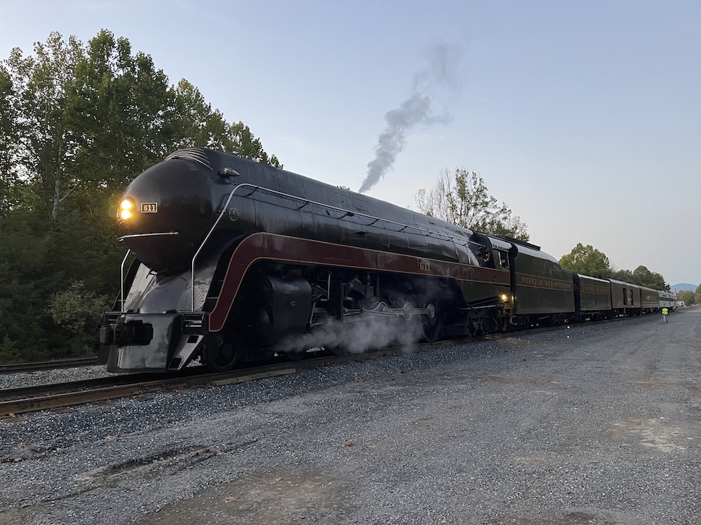 Streamlined steam locomotive sits on a siding during the early evening.