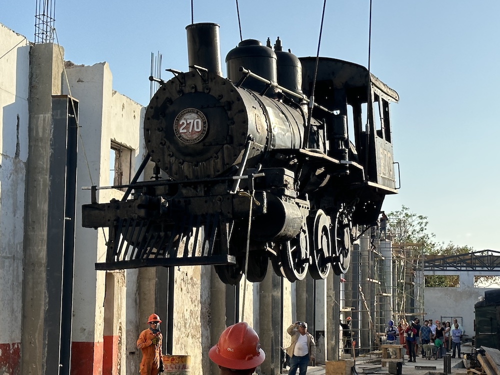 Steam locomotive being lifted by crane. Yucatán Railroad Museum redeveloping at Mérida’s new great park.